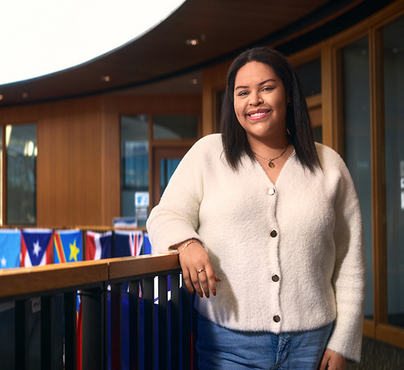 Woman in a t-shirt with a star on it leans against a railing